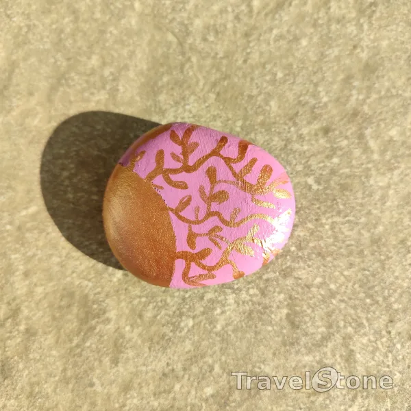 Painted painting stone by artist Ella showing pattern. Copper and pink painted on TravelStone