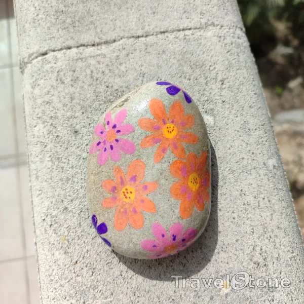 Painted painting stone by artist CJ showing plants. Flower Power TravelStone