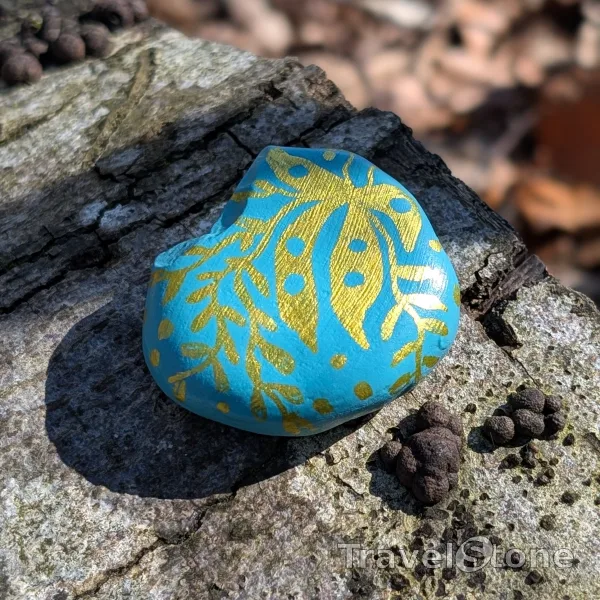 Painted painting stone by artist CJ showing pattern. turquoise and gold pattern. Acrylic colour