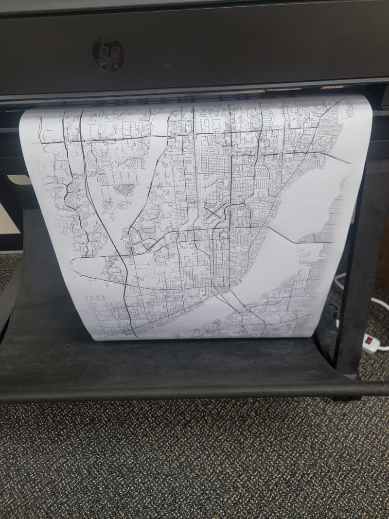 An HP wide-format roll printer in the store on Summerlin Rd with a street map of Fort Myers coming out into the catch tray