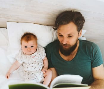 papa lisant une histoire à son bébé dans son lit