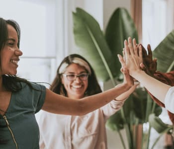 sororité : femmes souriant et se tapant dans la main