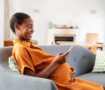 femme enceinte dans son canapé pendant son congé maternité en attendant bébé