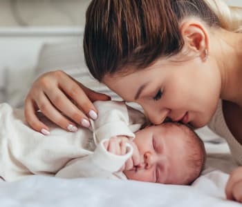 maman en train d'embrasser son bébé nouveau-né