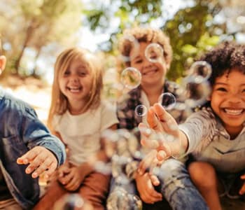 4 enfants qui s'amusent et rient ensemble en plein air