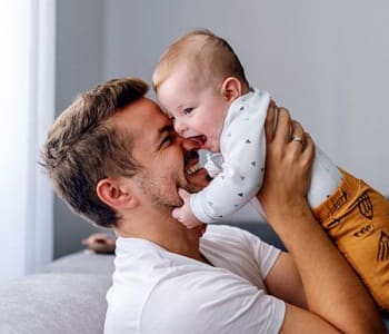 Homme heureux qui porte un bébé dans les bras