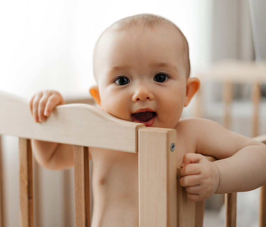 bébé dans son lit à barreaux