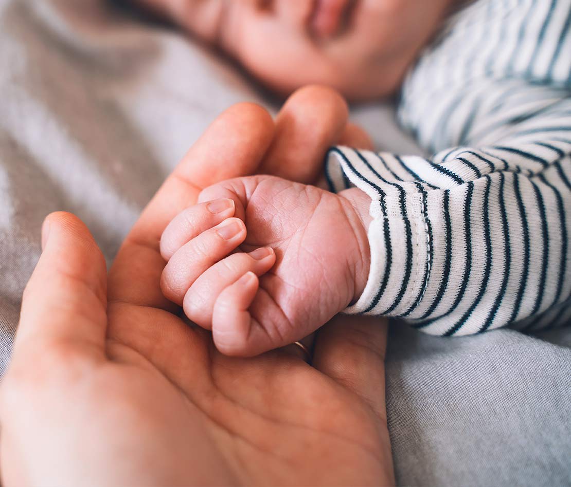 main de bébé nouveau-né dans une main d'adulte