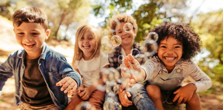 4 enfants qui s'amusent et rient ensemble en plein air