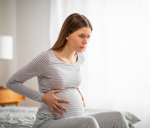 femme sur un lit ressent des contractions