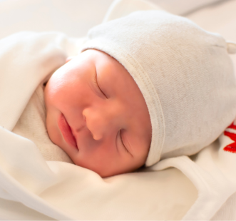 bébé qui dort avec un bonnet blanc