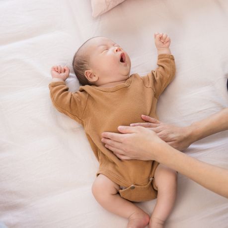 bebe qui vient de naitre avec les bras en l air et la bouche ouverte