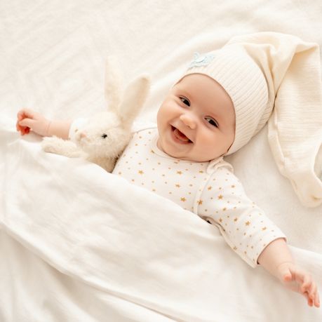 bebe allonge avec bonnet sur la tete