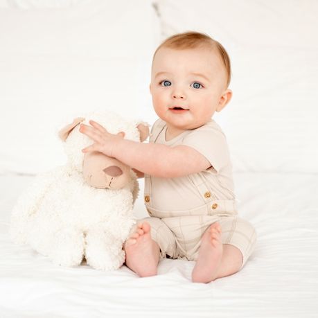 bebe assit avec une peluche a cote de lui