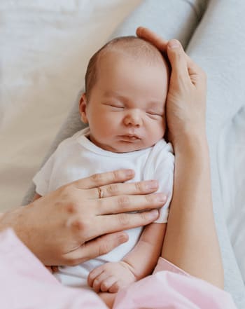 bebe allonge sur les genoux de sa maman