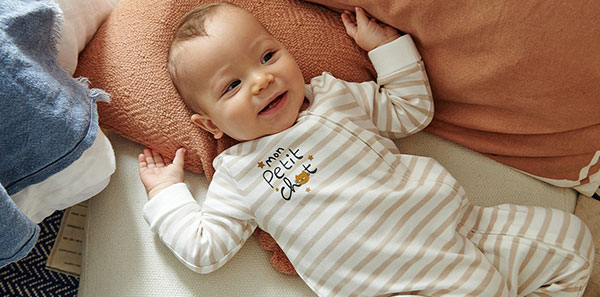 bébé souriant allongé sur le dos