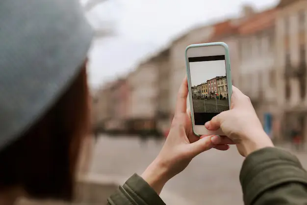 Teen taking photo on phone in Indian street market