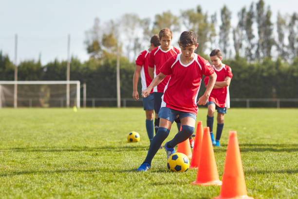 Teen practicing football dribbling on ground