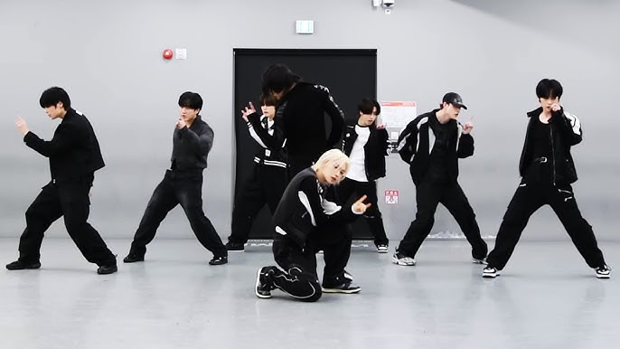 Teen practicing K-pop dance in cleared room with phone