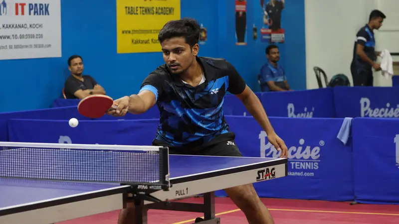 Table tennis player mid-rally with focused technique