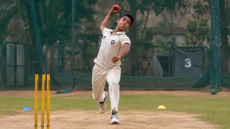 Teen spin bowler practicing