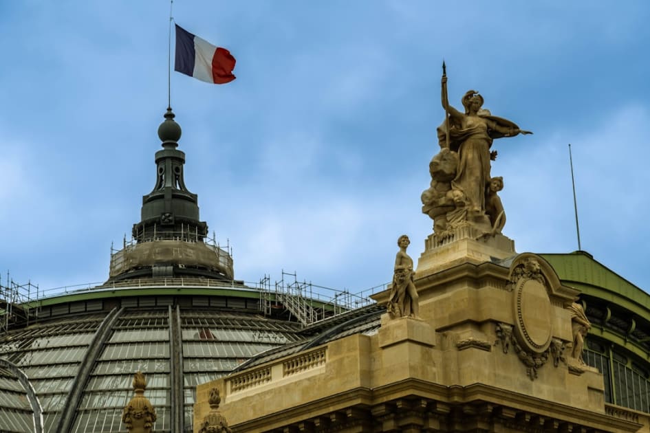 a statue of a woman holding a flag on top of a building