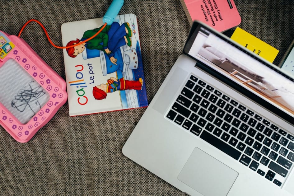macbook pro beside white and pink book