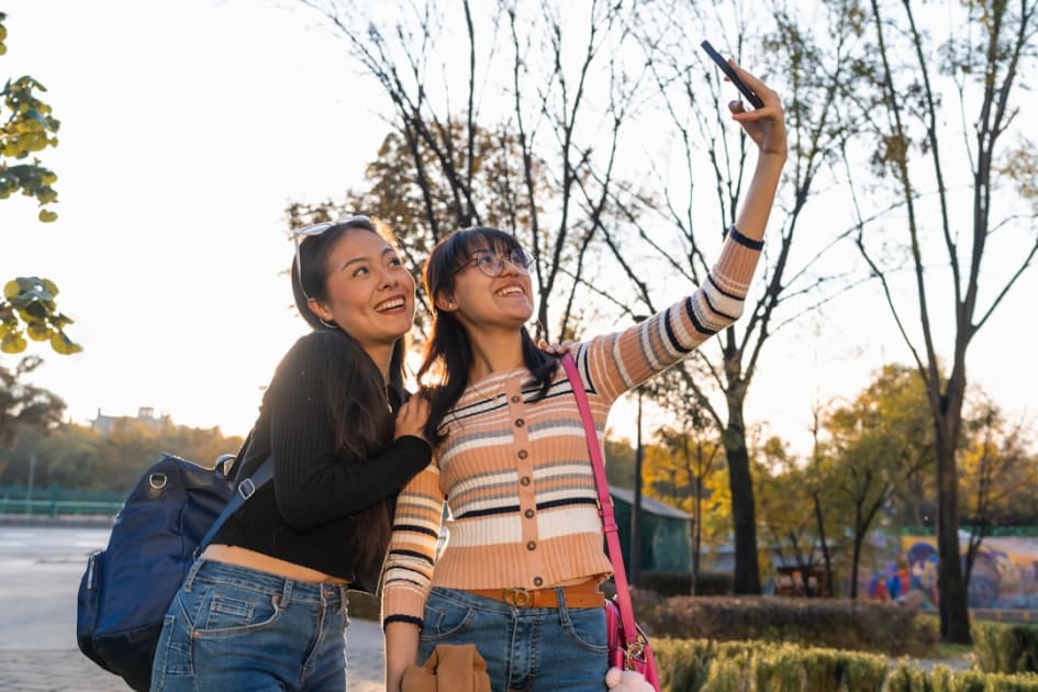 Two women taking a picture with a cell phone