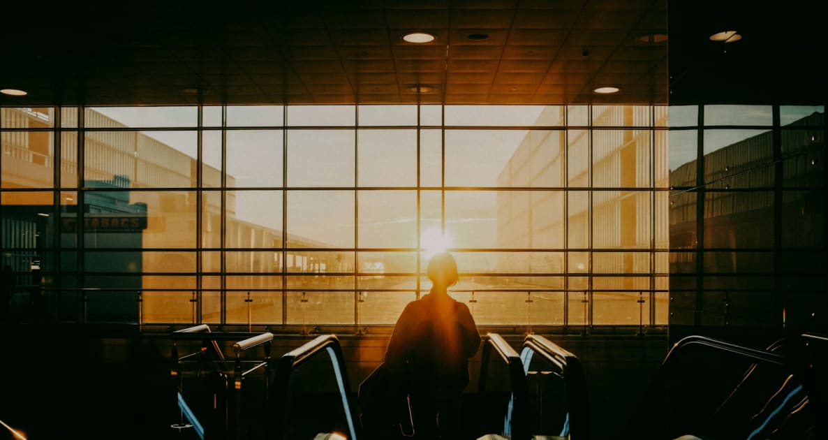 A person standing in front of a window at an airport