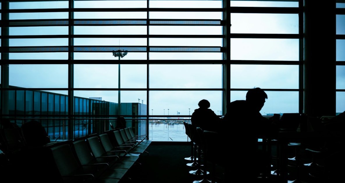 People silhouetted at an airport's waiting area