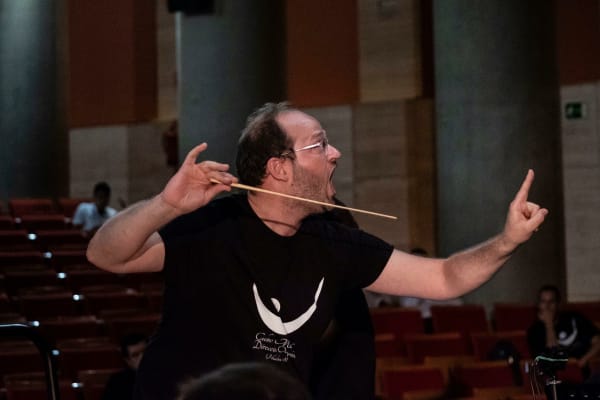 Daniele Camiz durante una prova, gesto energico con la bacchetta orizzontale.