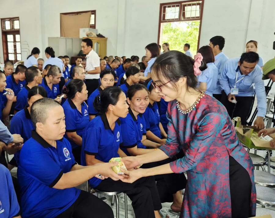 Bà Trần Thị Then, Giám đốc Công ty TNHH Dịch vụ Phần mềm Sao Khuê (áo dài) trao quà tận tay cho các bệnh nhân tại Trung tâm Nuôi dưỡng người tâm thần Nam Quảng Trị - Ảnh: K.S