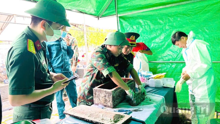 Lấy mẫu sinh phẩm hài cốt liệt sĩ - Ảnh: C.T