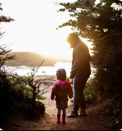 Adult and child walking by the water