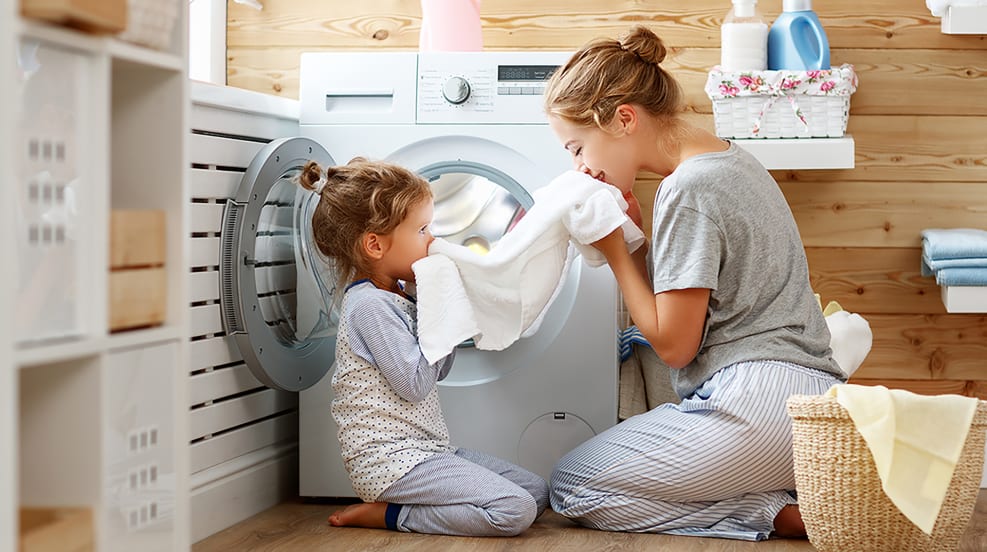 Woman and Child smelling clean towel that came out of the dryer