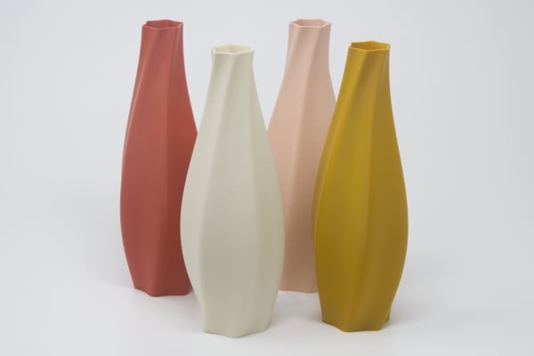 Four twisting colored vases on a white background.