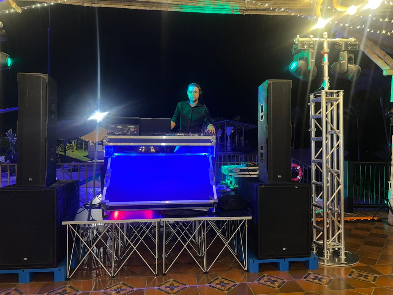Montaje de tarima con parlantes profesionales, truss y DJ al aire libre