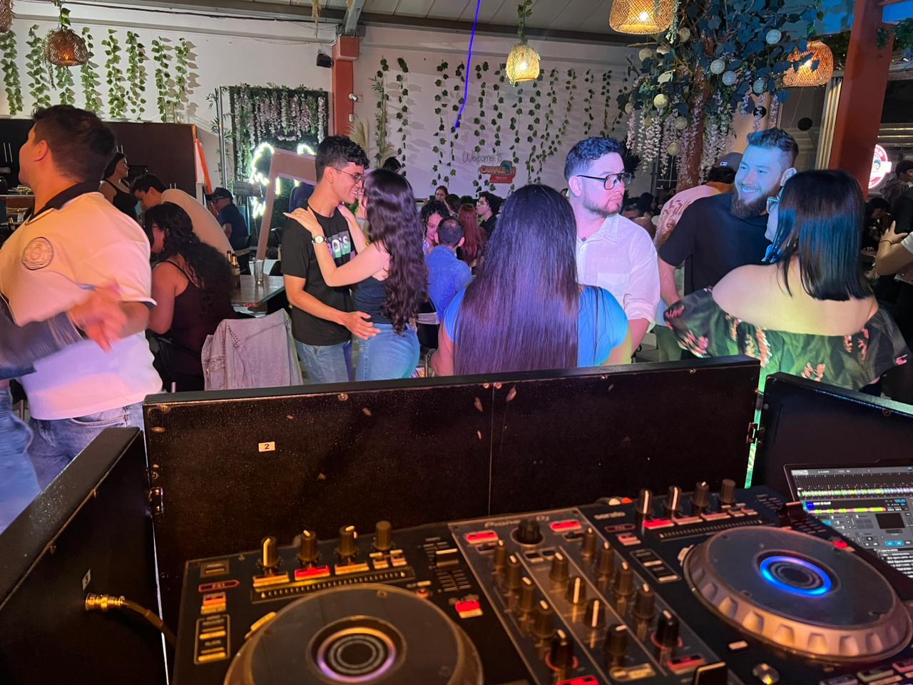 Vista desde el controlador DJ con la pista de baile llena de invitados