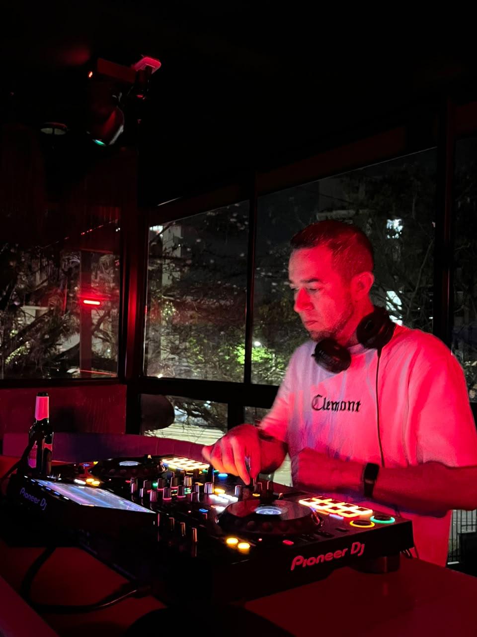 DJ Javi BPM mezclando en controlador Pioneer bajo luz roja