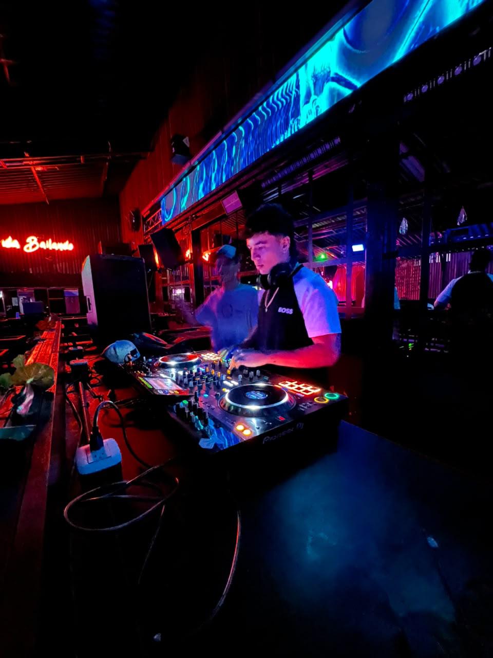 DJ SanTech mezclando en discoteca con luces rojas y azules
