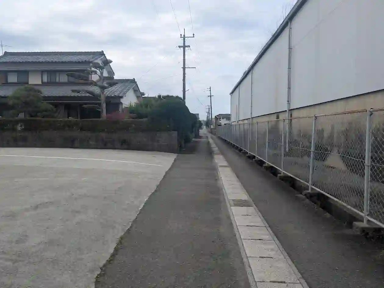 日向市財光寺エリアの住宅街にある細い通路とフェンス沿いの街並みの様子