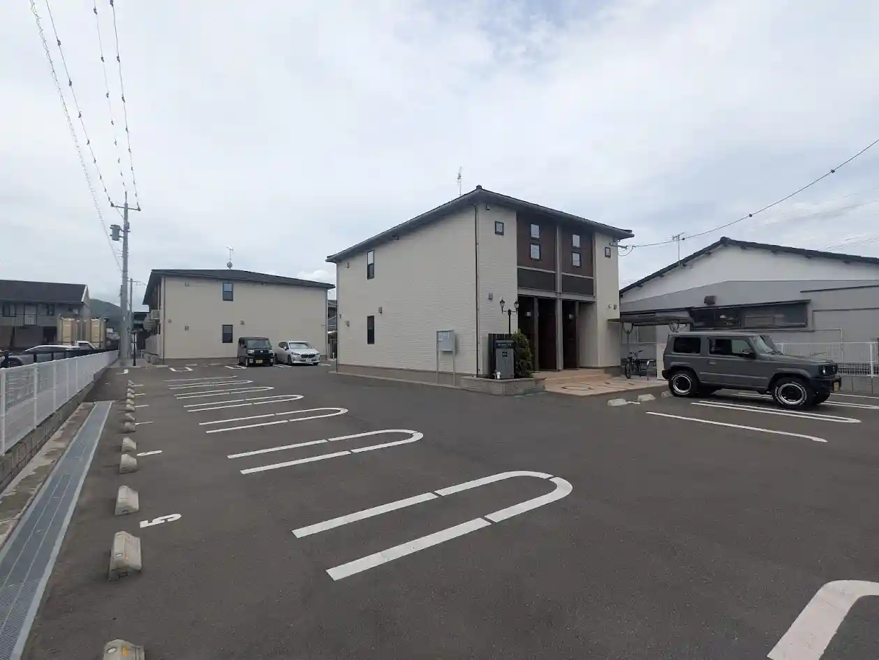 日向市財光寺にある2階建てアパート「オレガノ」の外観写真。建物前面にゆとりのある駐車スペースを完備。