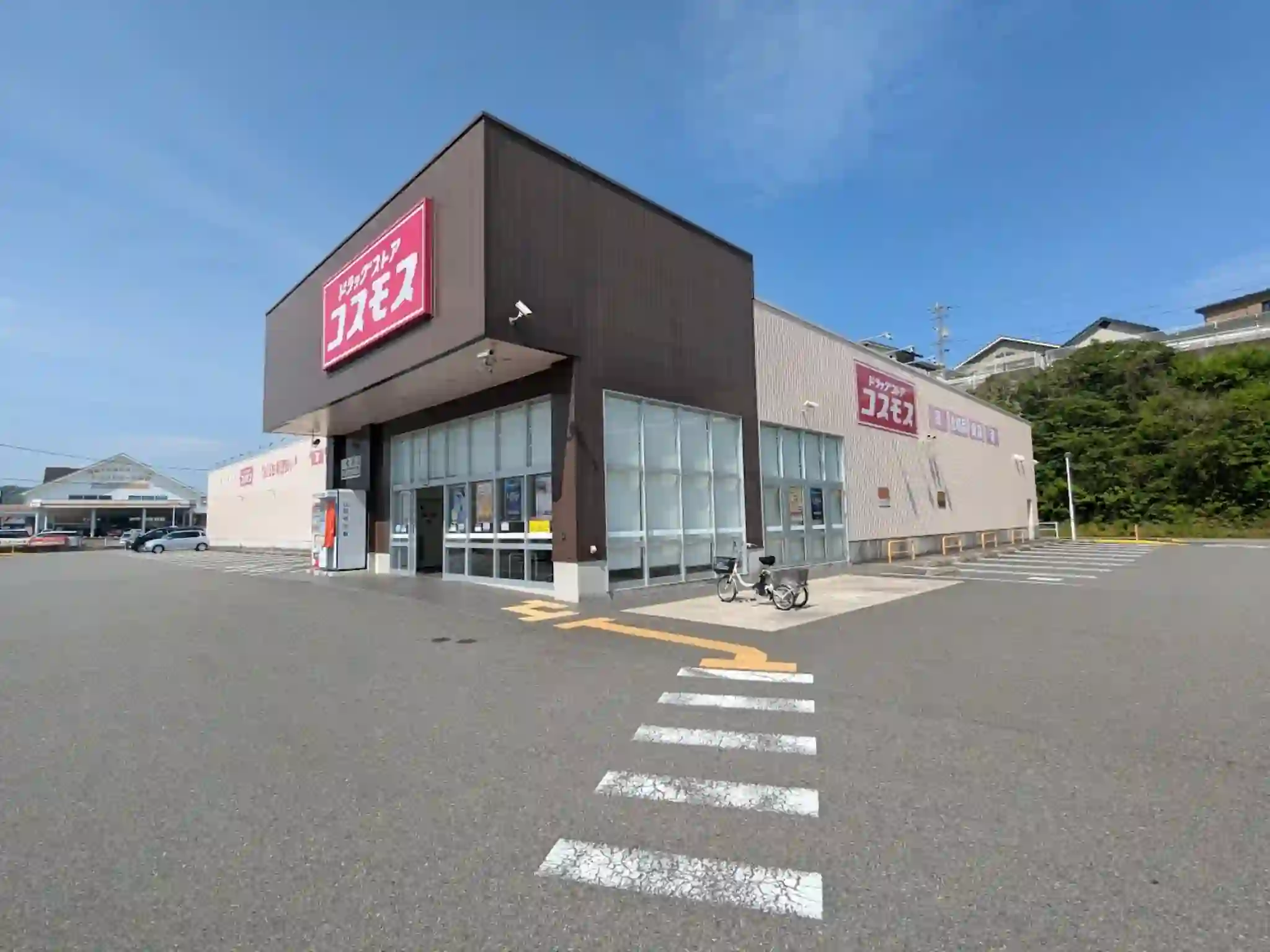 日向市にあるドラッグストアコスモス亀崎店の外観と広い駐車場の風景