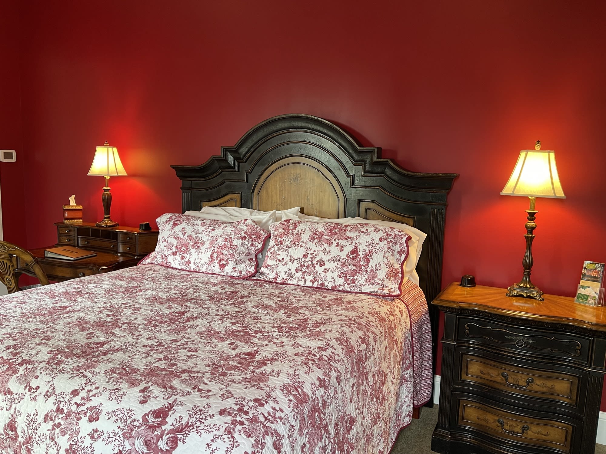 Oak Suite bedroom with warm red walls and historic details