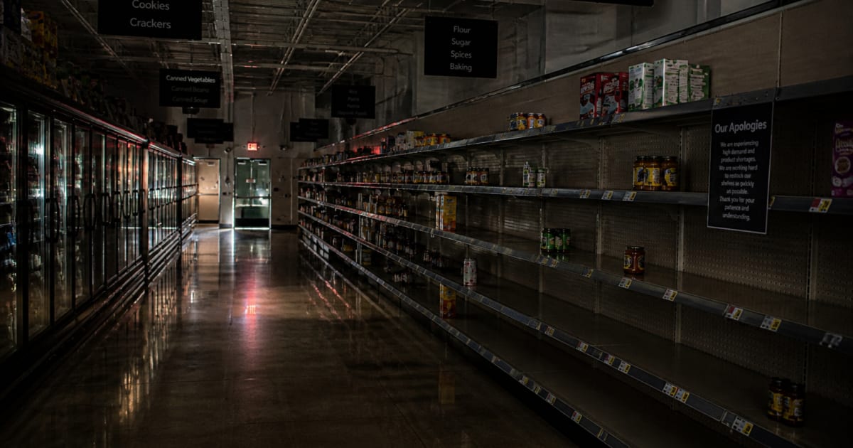 Dark grocery store interior during power outage blackout representing food supply disruption