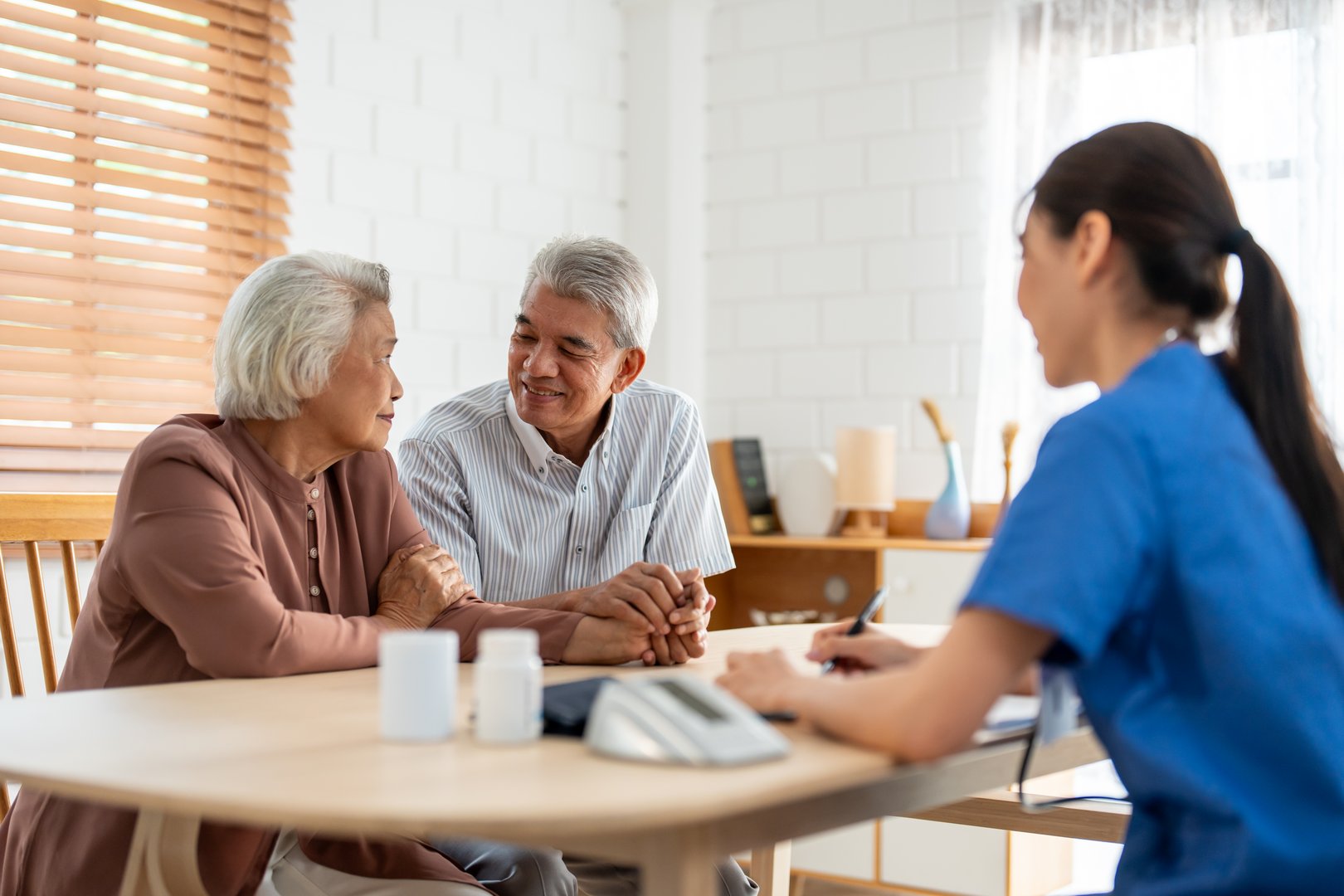 A care specialist consulting with a smiling senior couple at home
