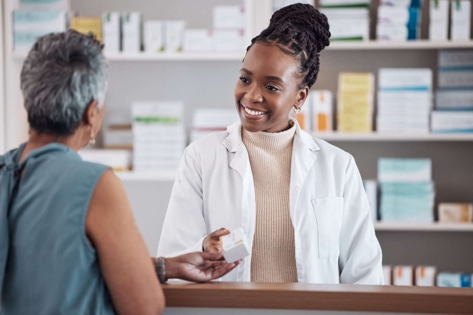 A pharmacist warmly assisting a customer with medication guidance