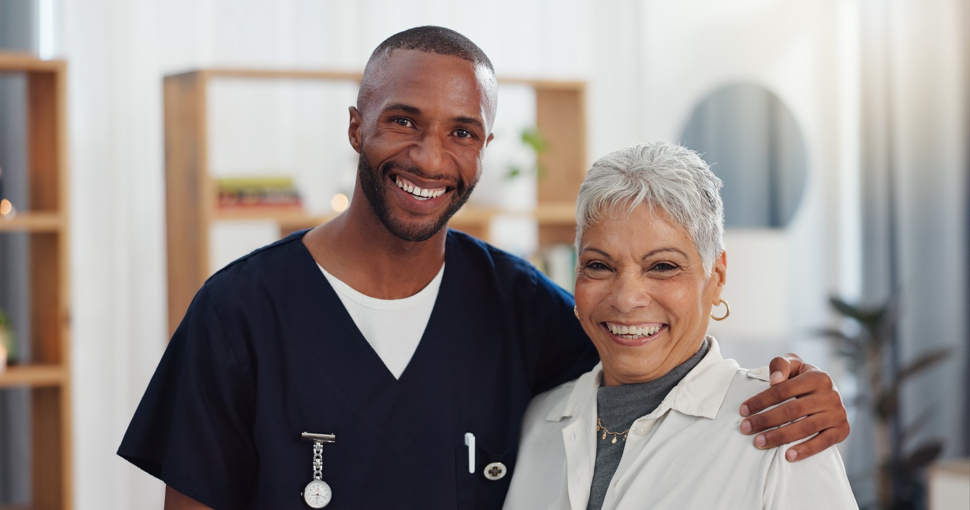 A caregiver sharing a warm embrace with a senior at home
