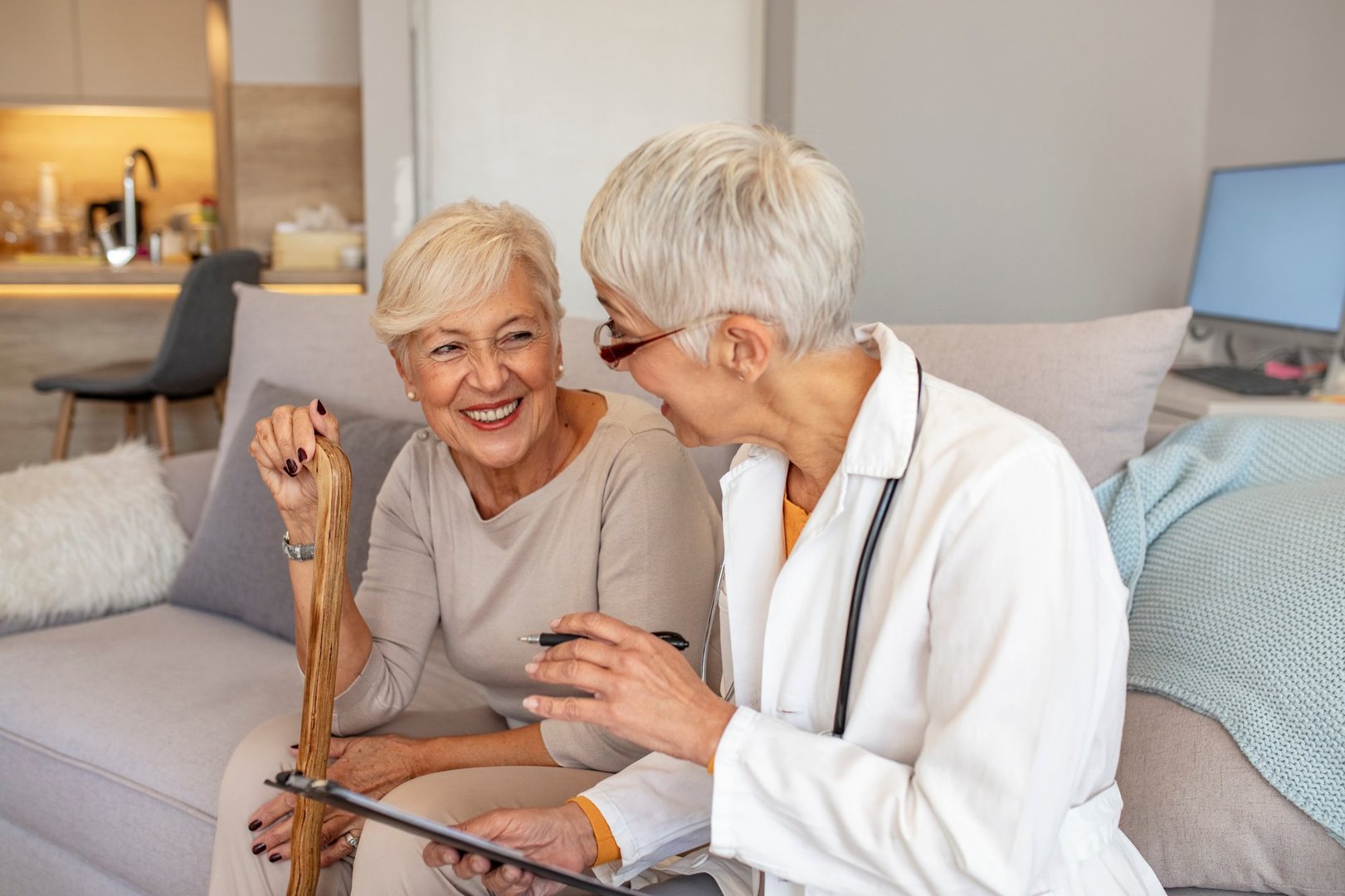 A doctor visiting a senior woman during a friendly home check-in