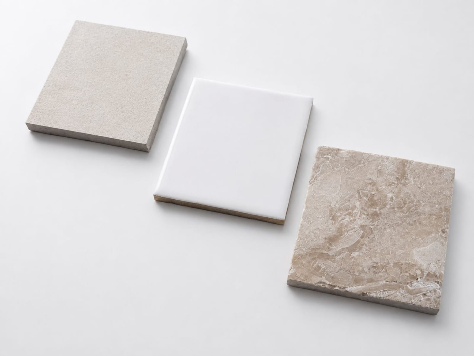 Porcelain, ceramic and natural stone tiles side by side, showing the difference in surface and finish for an Australian renovation.